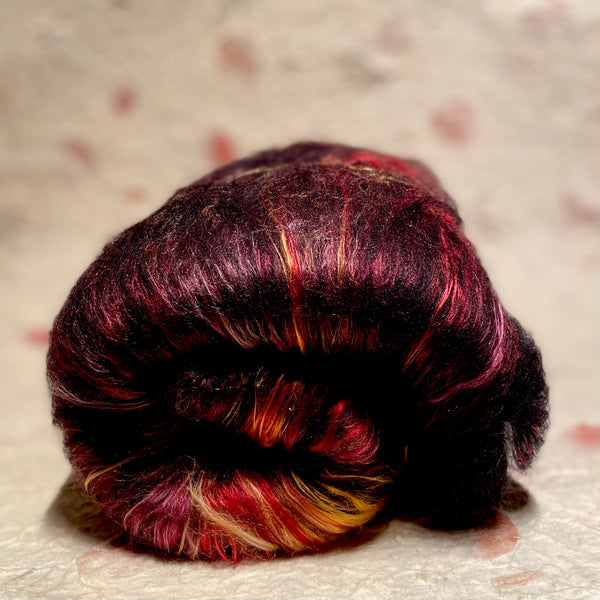 IxCHeL Fibre And Yarns Gothic Bunny Batt Tell-Tale Heart colour way with deep reds, gold and burgundy coloured mulberry silk and black merino and angora bunny