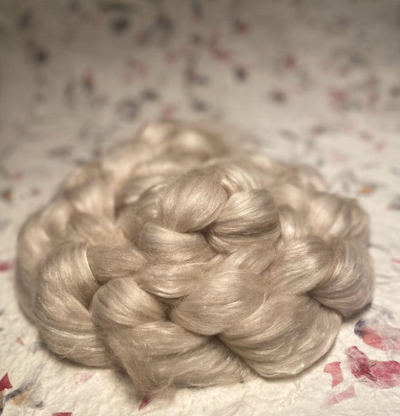 IxCHeL Fibre & Yarns Tundra Qiviut Blend Tops colourway Natural on a backdrop of flower paper 